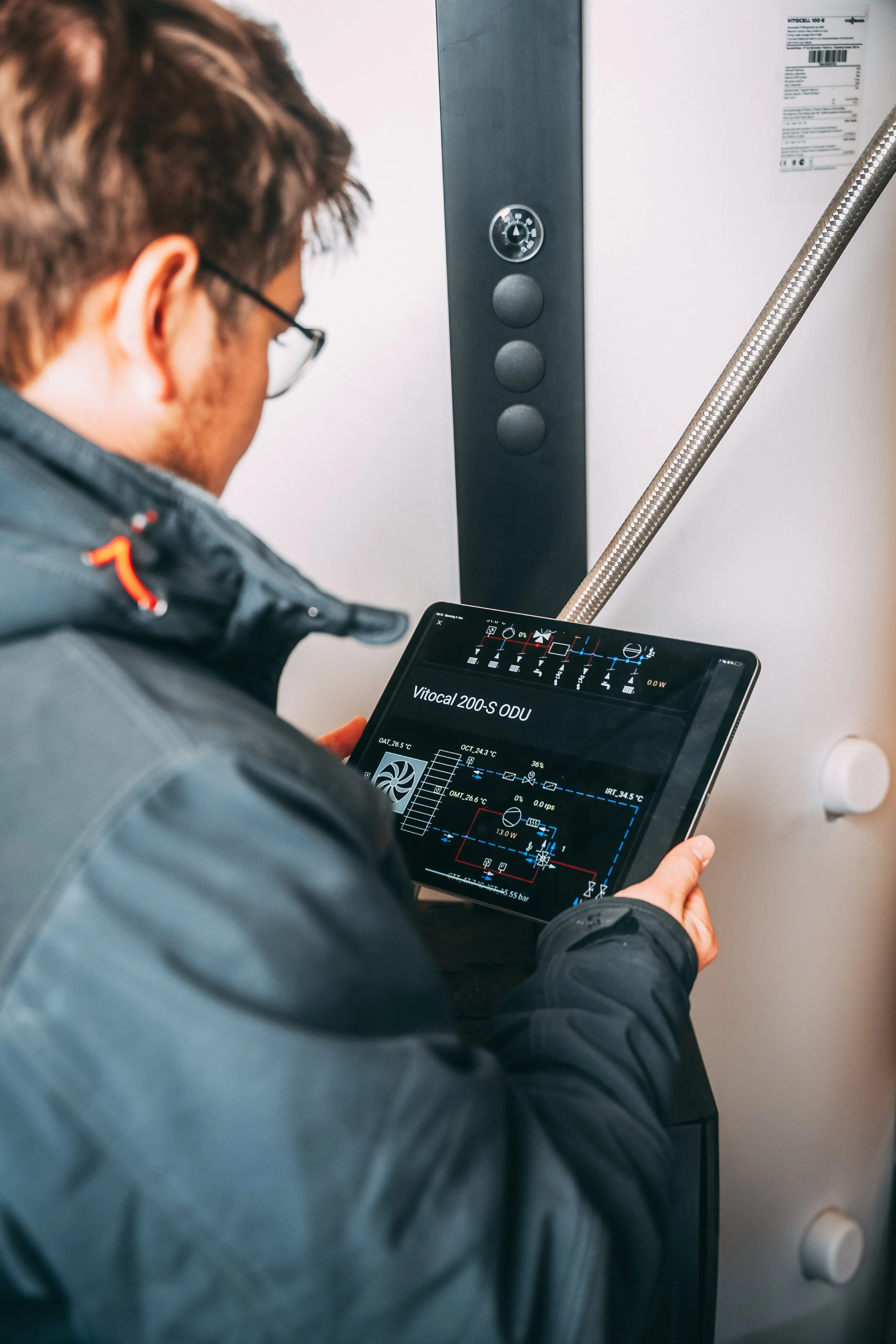 Monteur prüft eine Wärmepumpe per Tablet