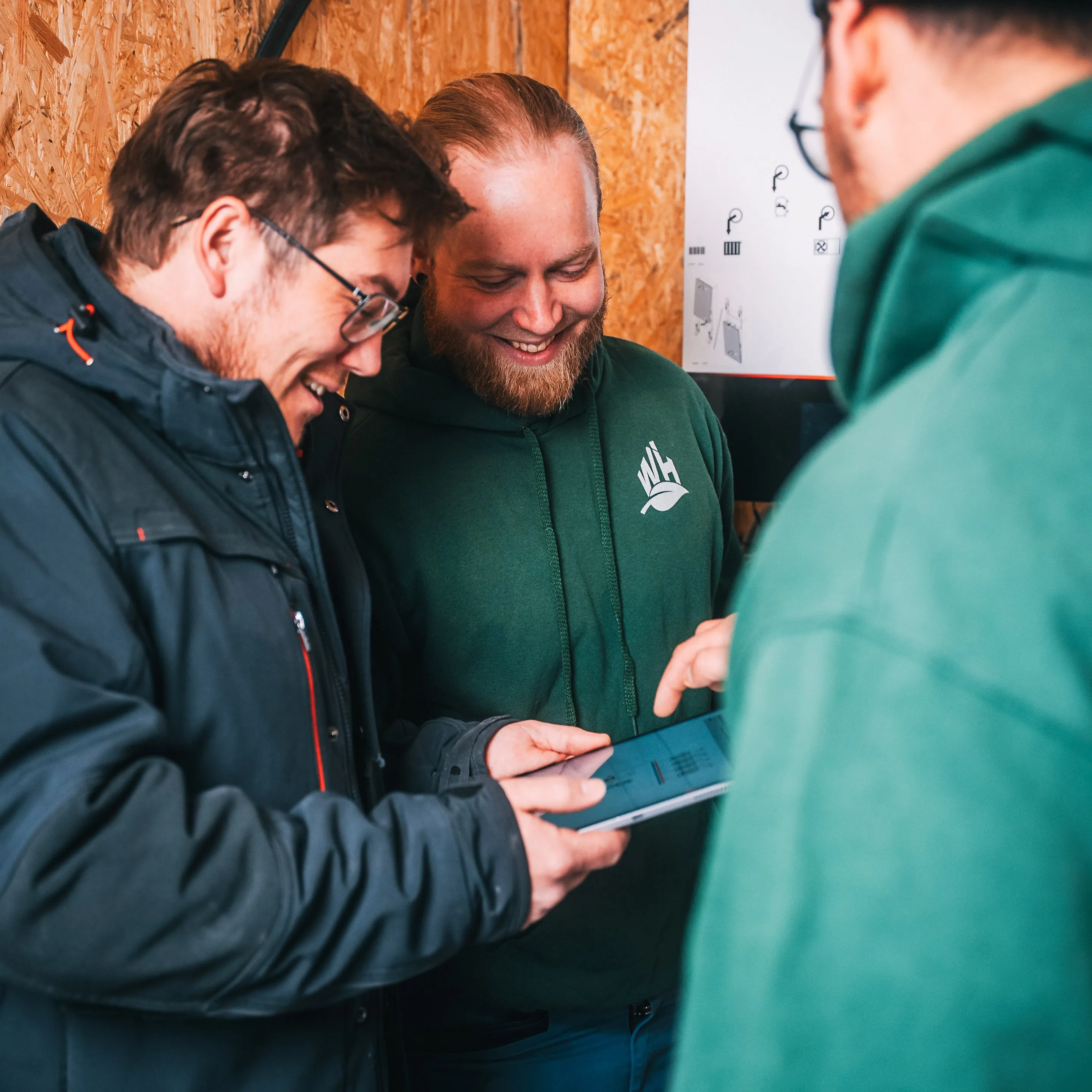 Drei Mitarbeiter von Wehner Haustechnik besprechen sich am Tablet